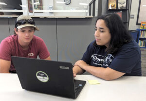 Annie Duncan, Career Coach, assists a student with registration on a laptop computer .