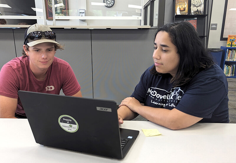 Annie Duncan, Career Coach, assists a student with registration on a laptop computer .