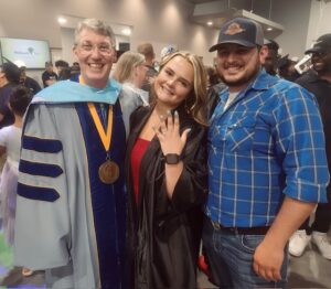 JW Kelley with the happy couple after the graduation proposal 2025